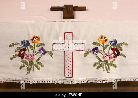 Croix et fleurs. Broderie. Eglise Notre-Dame de la Gorge. Les Contamines-Montjoie. / Cross and flowers. Embroidery. Broderie. Church of Our Lady of th Stock Photo