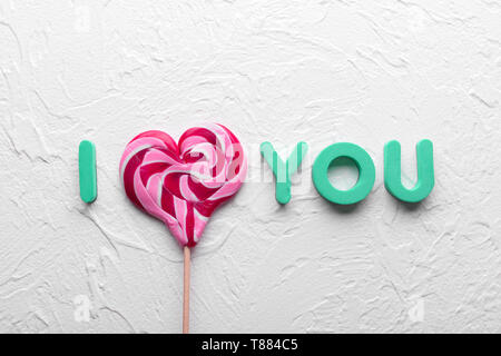 Phrase I LOVE YOU made of lollipop and letters on light textured background Stock Photo