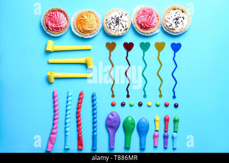 Flat lay composition with birthday party items and cupcakes on color background Stock Photo