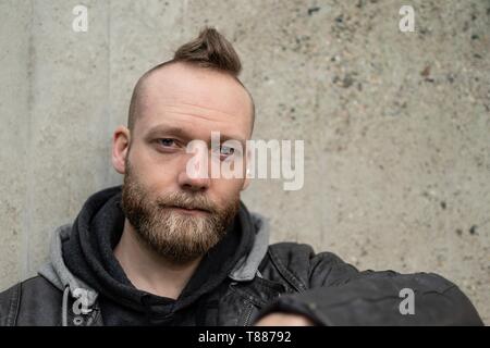 serious or calm young bearded man sitting in front of the camera Stock Photo