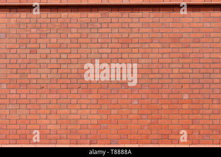 A photograph of a terracotta brick wall. Background texture, copy space, add your own text.  Red bricks in sunlight. Repetitive pattern. Stock Photo