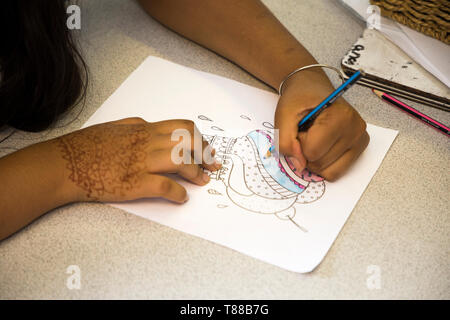 And example of a child / kid using poor / incorrect pencil grip during colouring in / pencilling at school. UK (108) Stock Photo