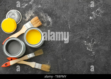 Cans of paint and brushes on grey background Stock Photo