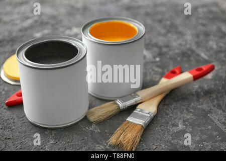 Cans of paint and brushes on grey background Stock Photo