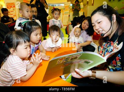 Beijing, China. 12th May, 2019. A staff reads a book for children in Beijing, capital of China, May 12, 2019. An early childhood education center held a picture book reading event to promote parent-child reading in Beijing. Credit: Liu Lianfen/Xinhua/Alamy Live News Stock Photo