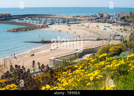 Lyme Regis, Dorset, UK. 12th May 2019. UK Weather: Visitors and beach goers enjoy the picturesque beach at the seaside resort of Lyme Regis on a hot and sunny Sunday.  Temperatures are set to soar with highs of 25 degrees celsius forecast for the coming week. Credit: Celia McMahon/Alamy Live News. Stock Photo
