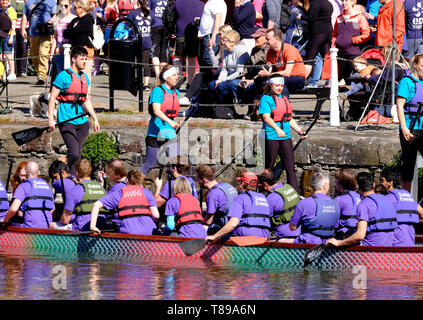 Gloucester, UK. 12th May 2019. Teams race dragon boats in Gloucester dock for local charities. Each boat has a brightly coloured Dragon Head at the prow and a crew of volunteers who paddle with lots of enthusiasm. Credit: Mr Standfast / Alamy Live News Stock Photo