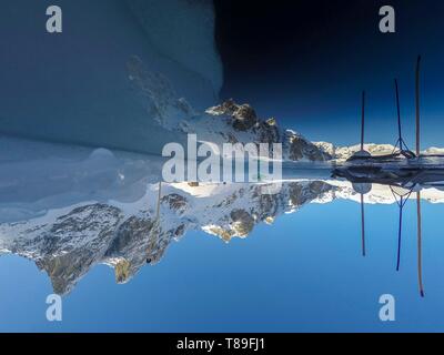 France, Isère (38), Belledonne, Chamrousse, Robert lakes bordered and dominated on the east by Petit Van (2,439 meters), Grand Van (2,448 meters) and Grand Sorbier (2,526 meters), reflecting the mountain peaks through a hole dug in the ice to allow diving Stock Photo