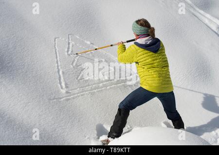 France, Haute Savoie, Massif of the Mont Blanc, the Contamines Montjoie, trails round in snow rackets with snow, person tracing the station logo in the snow Stock Photo