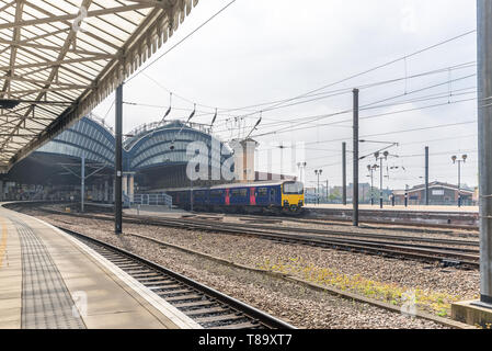 End of York Railway station where two19th Century canopies of iron and glass sit astride the platforms.  An ornate canopy is in the foreground. Stock Photo