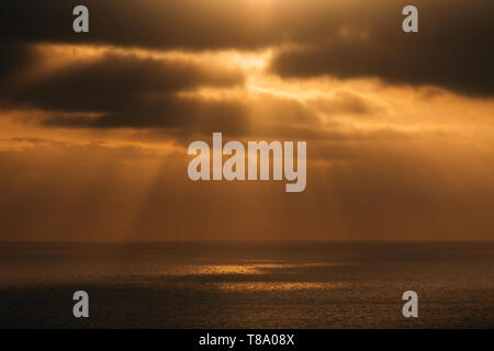 Dramatic sun rays over the Pacific Ocean at sunset from Torrey Pines State Reserve in San Diego, California Stock Photo