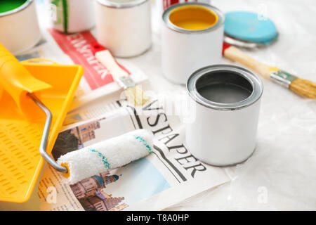 Paint cans with tools on table Stock Photo