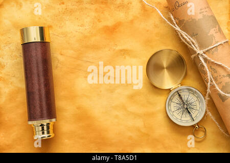 Vintage compass with spyglass and world map on old paper, top view Stock Photo
