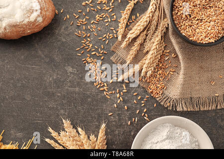 Composition with wheat grains, flour and products on grey background Stock Photo