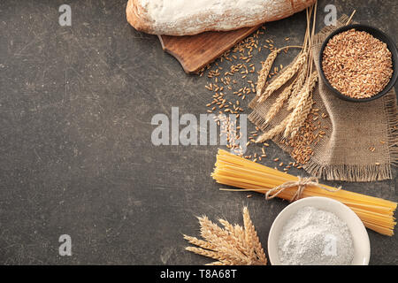 Composition with wheat grains, flour and products on grey background Stock Photo