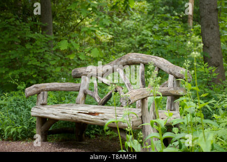 bench made of logs along path Stock Photo