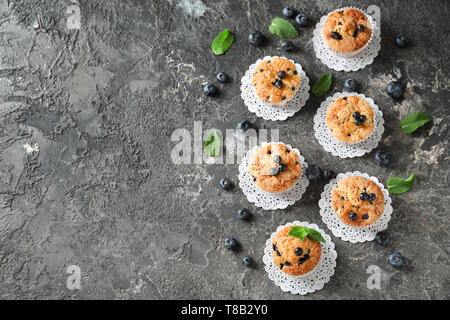 Tasty blueberry muffins on grey textured background Stock Photo