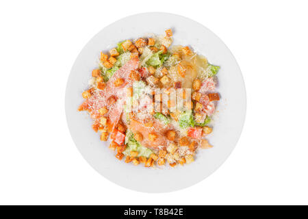 Caesar salad with three kinds of fish lobes, salmon, trout, biscuits, lettuce, cheese on plate, white isolated background, view from above Stock Photo