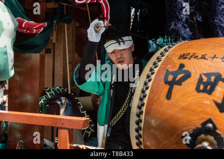 Karatsu, Japan - may 5, 2019 : young men in traditional costumes playing taiko drum during the parade to celebrate new imperial era 'reiwa' Stock Photo