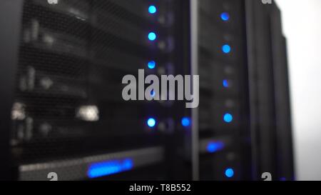 Data center, server room in a blurry background. Blinking blue led ligts. Handheld shooting, no stabilization. Stock Photo