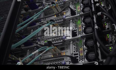 Running server. Optical cable close-up. Network devices technology Stock Photo