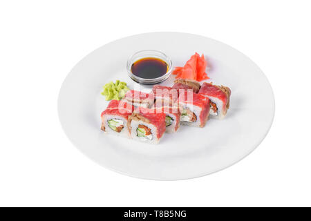 Sushi, rolls, uramaki with bacon, cucumber, cheese, meat and teriyaki sauce, marinated ginger and wasabi, white isolated background, side view Stock Photo