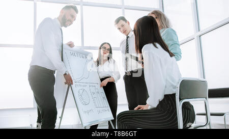 business team standing next to flipchart and discussing their ideas. the concept of teamwork Stock Photo