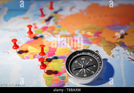 Modern compass with pushpins on world map Stock Photo