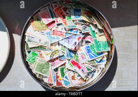 multicolored stamps in a tin Stock Photo