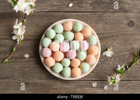 Mini Mochi - traditional japanese dessert on wooden background, top view, copy space. Stock Photo