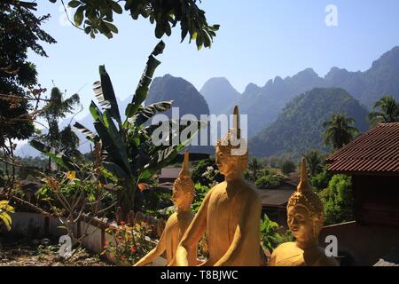 Panoramic view on karst hill landscape with golden buddha statues from a temple near Vang Vieng, Laos Stock Photo