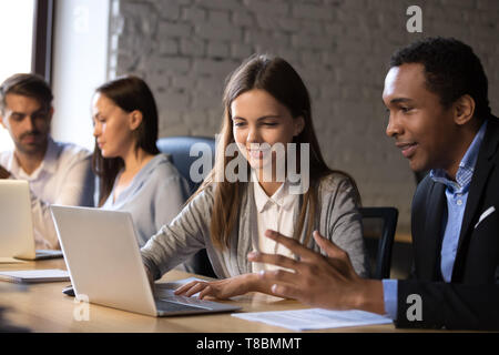 Diverse male female colleagues working together make presentation use computer Stock Photo