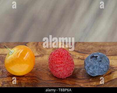 close up of raspberry, blueberry and berry of physalis on wooden background with copy space Stock Photo