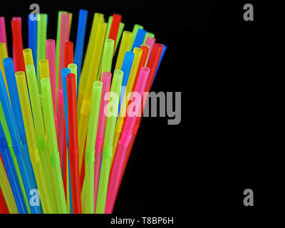 close up od different colored plastic drinking straws isolated on black Stock Photo