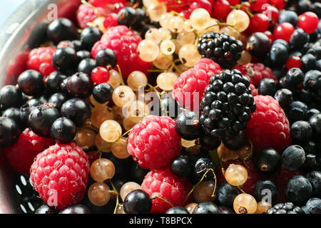 Assortment of fresh ripe berries in colander, closeup Stock Photo