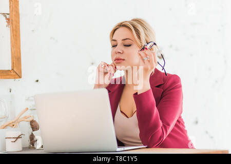 Successful business woman enjoying her work in home office. Closeup photo of elegant charming lady smiling making up plan for weekend, dreaming after  Stock Photo