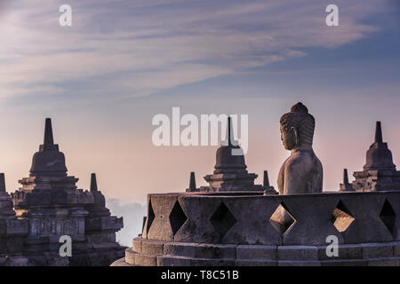 Buddha statue at sunrise, Borobudur temple complex, Borobudur, Yogyakarta, Java, Indonesia Stock Photo