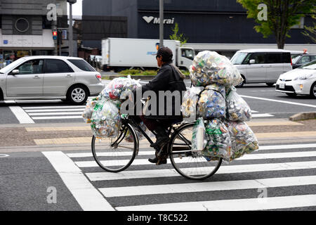 cyclist transporting bags for recycling Japan Stock Photo