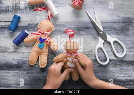 Child making felt Christmas toys at wooden table Stock Photo