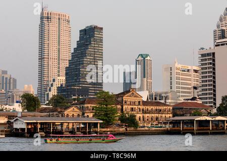 Skyline of the Bang Rak district, front old fire station Bangrak, boat on the Mae Nam Chao Phraya, Bangkok, Thailand Stock Photo