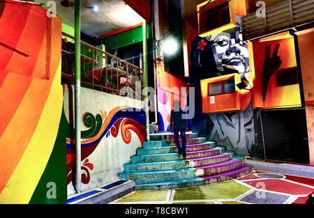 People walking past colorful mural in residential alley, Kuala Lumpur, Malaysia Stock Photo