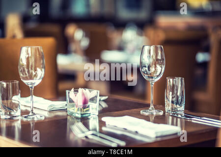 Luxury table with glasses, napkins and cutlery in restaurant or hotel Stock Photo