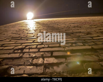 Corner of old rough and uneven brick wall in the light of a lantern Stock Photo