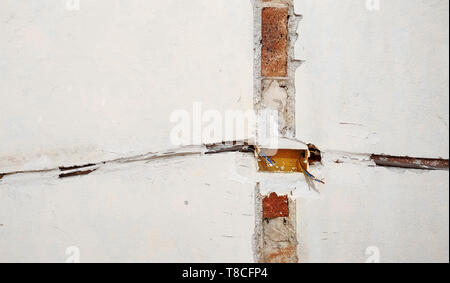 Electrical wires in the wall. Socket holes and electrical cables on the wall, renovation concept. Electrical wiring installation. Stock Photo