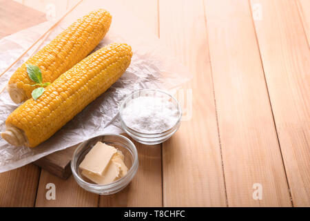 Composition with boiled corncobs on wooden table Stock Photo