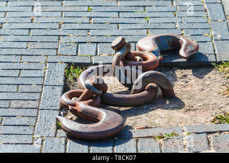 Old and rusty mooring ring for ships fixing. Dock for small boats. Stock Photo