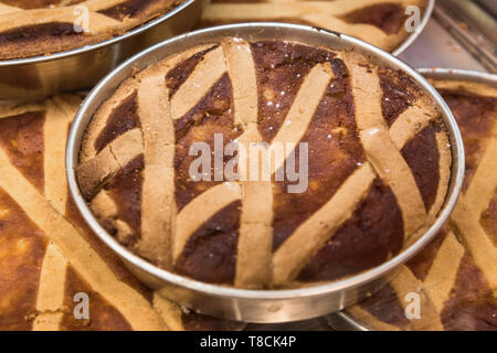 Traditional Pastiera Napoletana Easter cakes in metal baking tins on display at a bakery in Naples, Italy. Authentic Neapolitan lattice tart. Stock Photo