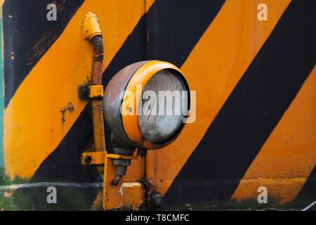 Landschaftspark Duisburg, Germany: Close up of electric lamp of an old locomotive  with yellow and black stripes Stock Photo