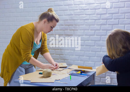 Two professional women decorators, designers making envelopes at workshop, studio. Design, handmade and art concept Stock Photo