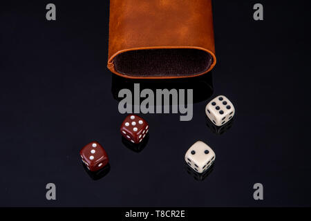 Dice with dice cup on black background Stock Photo